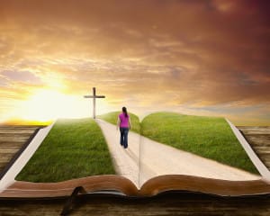 A woman walks along a road on a book towards the cross.